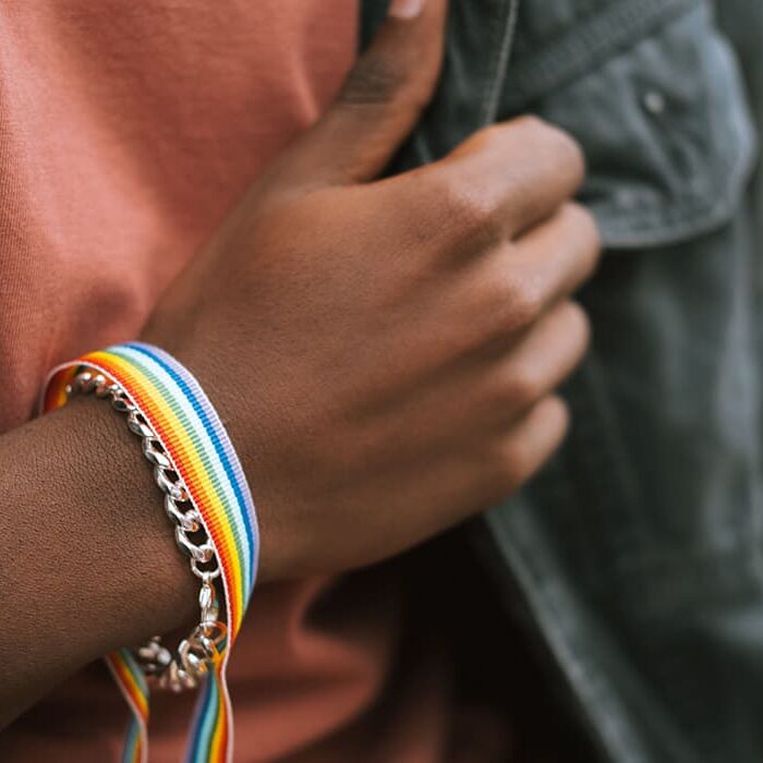 A brown hand with rainbow bracelet