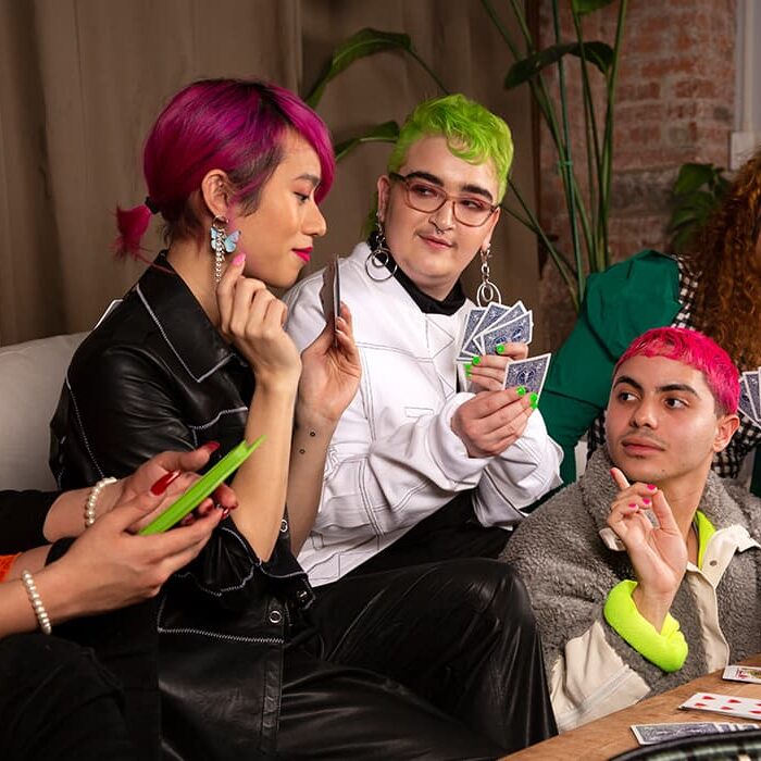 A group of young people with coloured hair playing cards