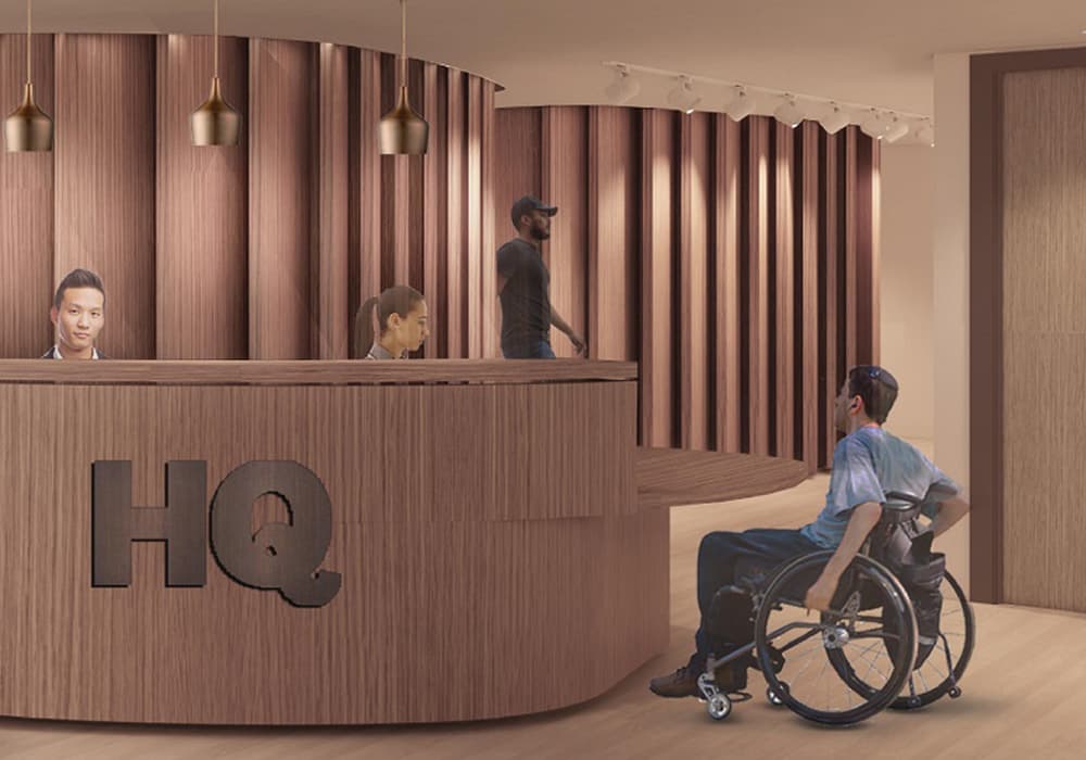 A rendering of a wooden reception desk with the HQ logo displayed on it, including two people behind the desk and a guy in a wheelchair asking for assistance